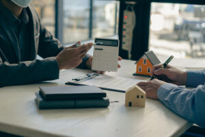 Home agents talk to new home buyers and offer good interest rates and calculate clients on mortgage financing to help make real estate concept decisions.